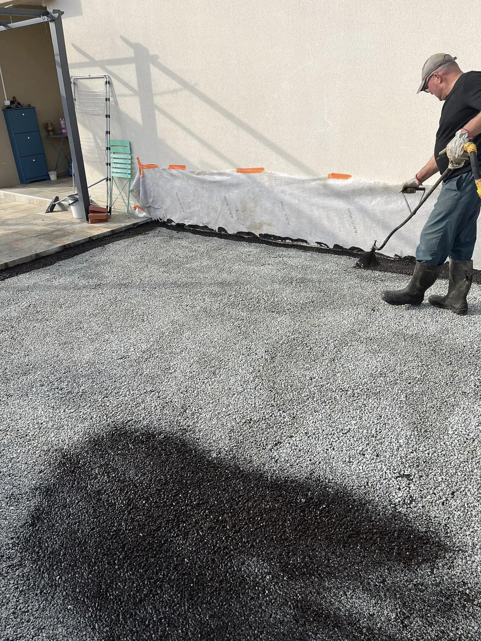 goudronnage en Revetement bicouche gris et mise en place de gravier au tour de l’habitation