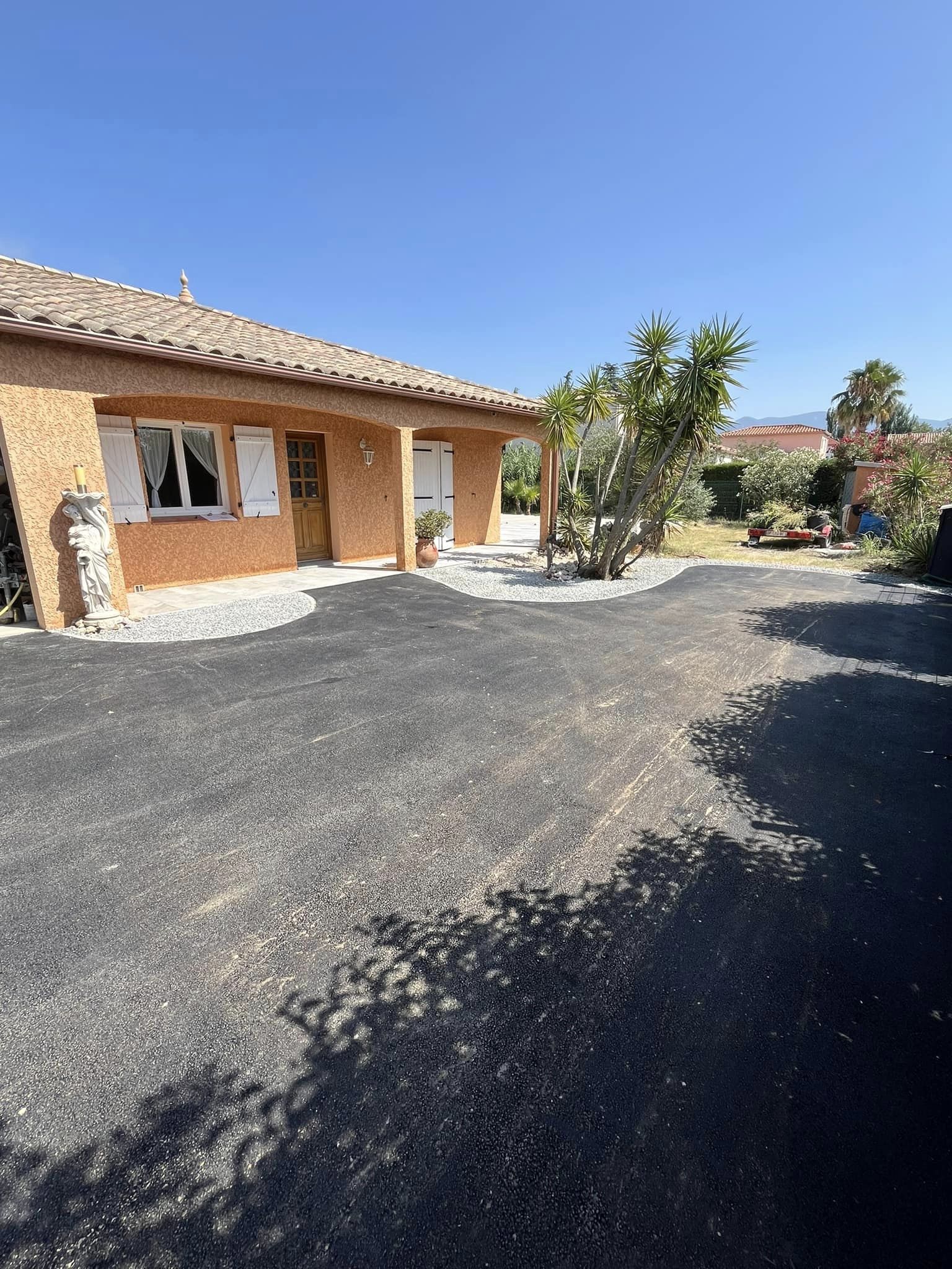Aménagement d’une cour en enrobé avec bordure granité et espace vert en gravier