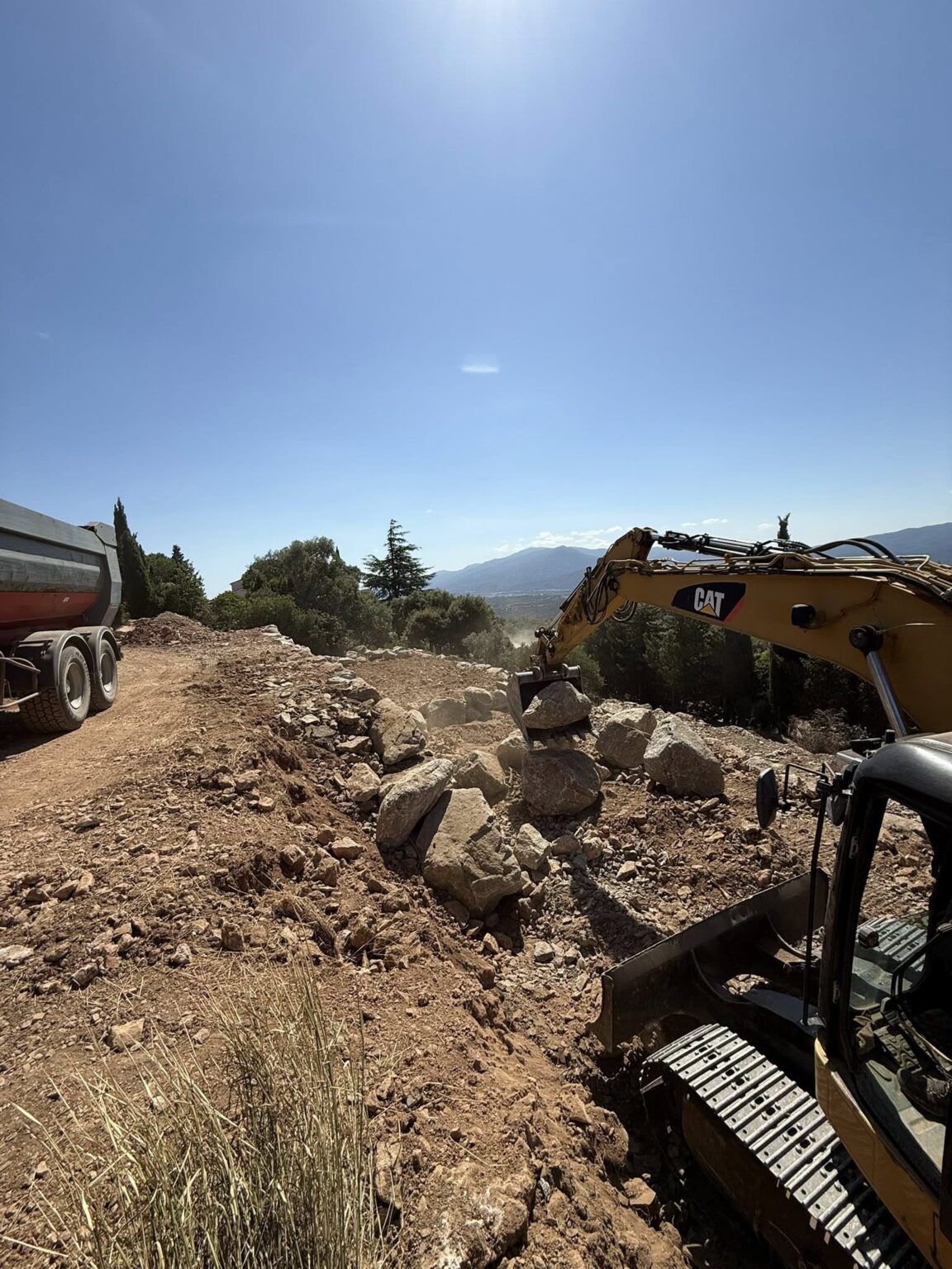 Création de paliers en enrochement pour structurer le terrain et lui donner du relief - Apport de terre végétale sur l’ensemble du jardin, prêt à être végétalisé.