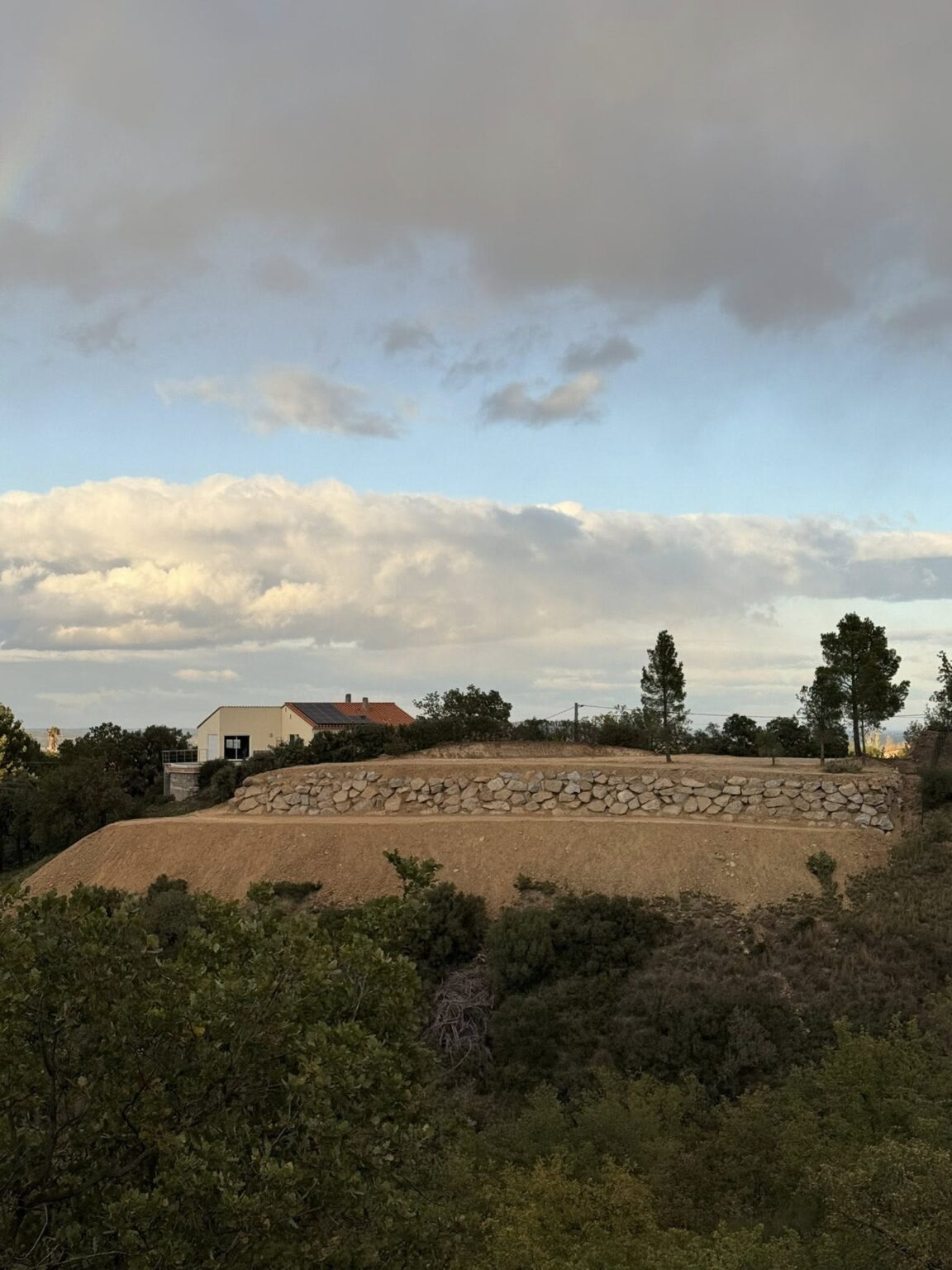 Nettoyage complet de la parcelle • Évacuation de la végétation 🌿 • Plus de 1 300 m³ de terre déplacés en déblais/remblai ⛏️ • Mise en place de 300 tonnes d’enrochement à Montesquieu