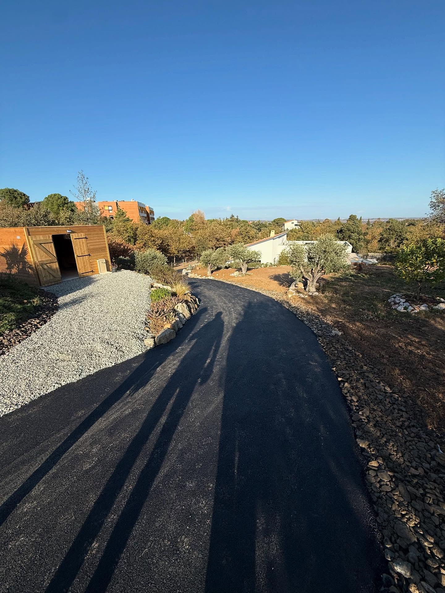 Chantier à Villelongue dels Monts : enrochement de type granite, réalisation d’un accès en enrobé avec bordures en schiste concassé, et création d’une aire de retournement en gravier granitique au fond de la parcelle.